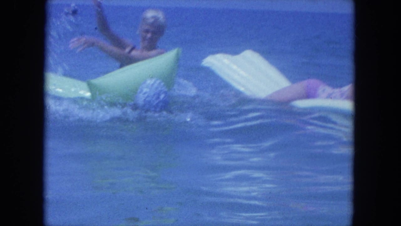 In the Clearwater 8mm scene, women play in the water around green and white inflatable rafts under a blue horizon.