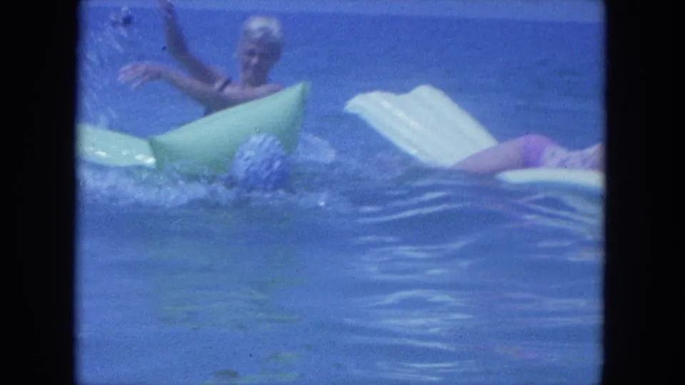 In the Clearwater 8mm scene, women play in the water around green and white inflatable rafts under a blue horizon.