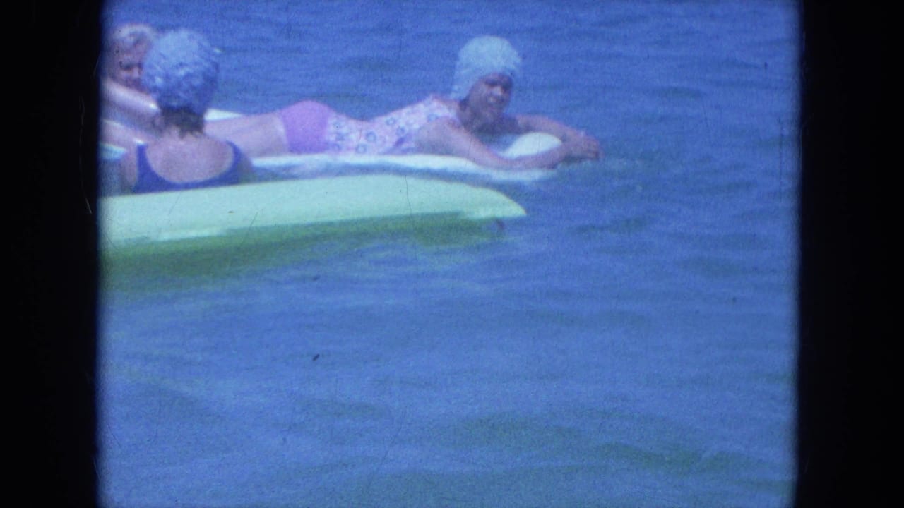 Women cluster around pale inflatable mats in the ocean during a 1964 Clearwater beach home movie.