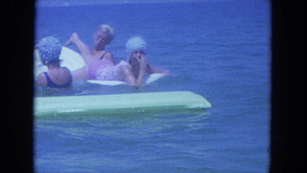 Women lounge on rafts while one raises her legs above the water.