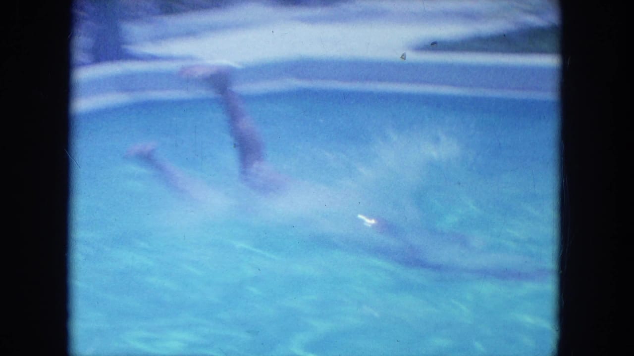 A blue 8mm frame shows the diver underwater after entering the motel pool, with motion blur and rippled light across the water.