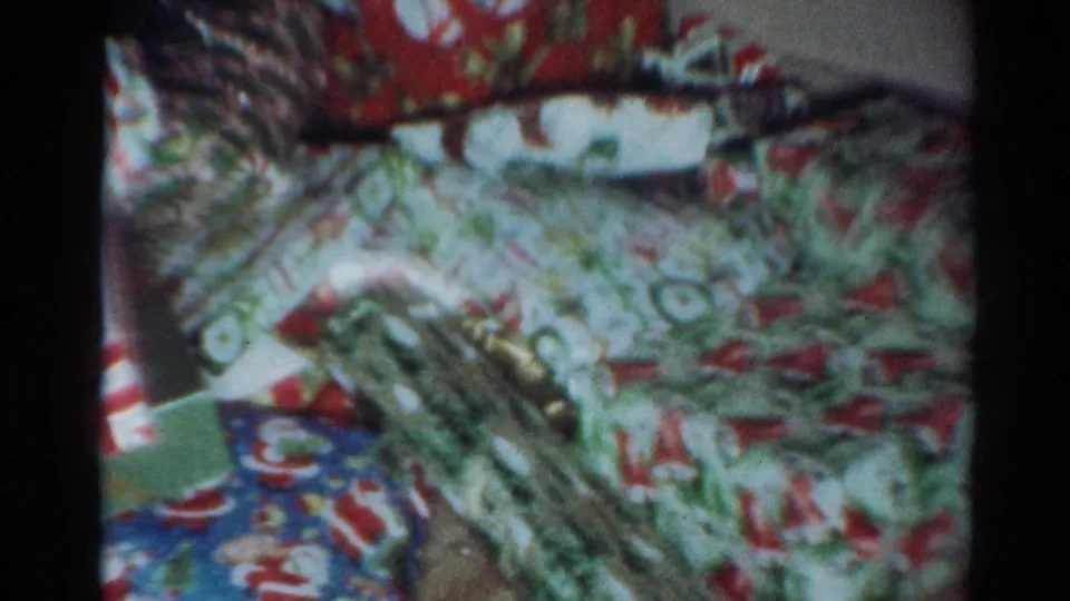 1964 Cleveland 8mm frame showing a cluster of Christmas packages with floral, geometric, and striped wrapping paper.