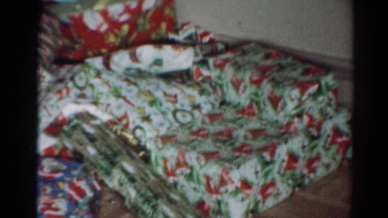 Wrapped Christmas presents stacked on a floor in bright patterned paper.