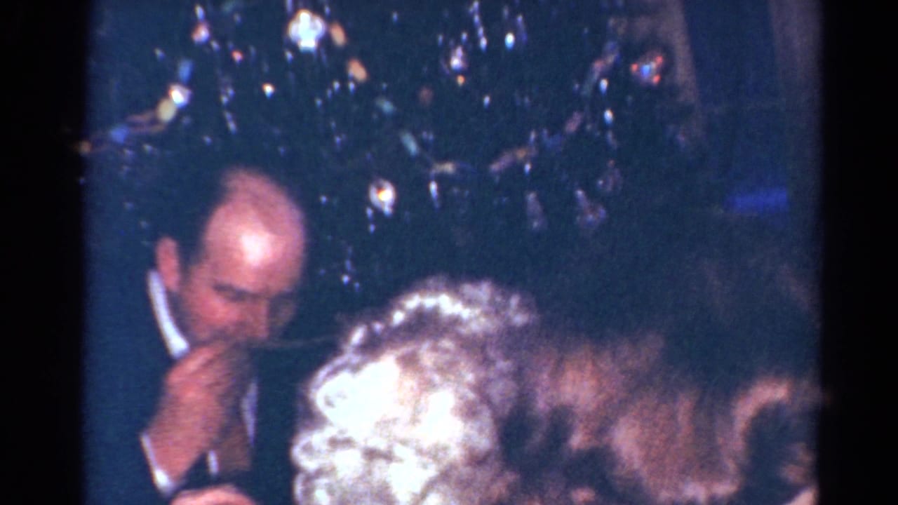 1964 Cleveland Christmas dinner frame showing a suited man at the table with adults in the foreground.