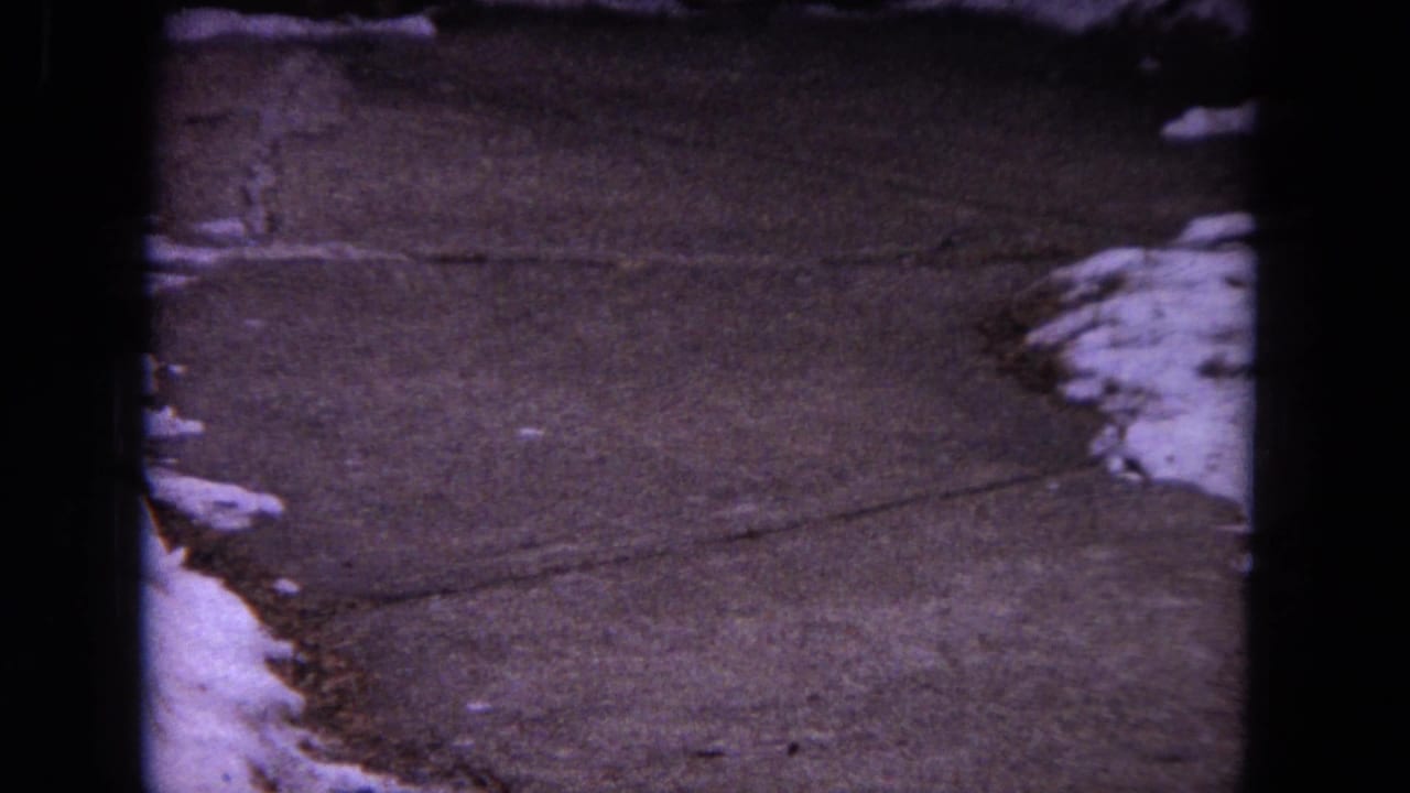 Snow-edged concrete walkway seen through dark 8mm frame borders.