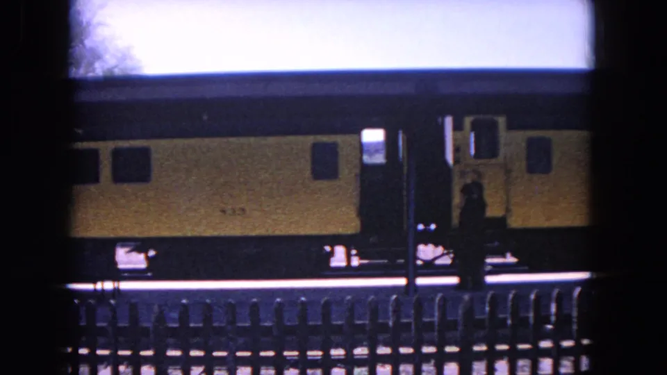 The yellow rail car fills the frame as a dark figure moves near the doorway on the Evanston station platform.