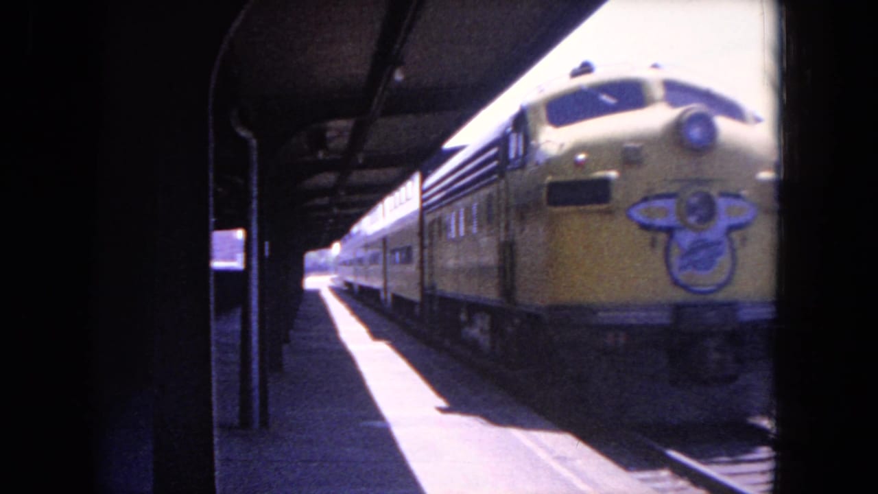 Yellow passenger train close to a covered station platform.