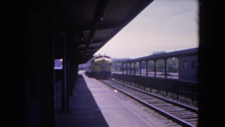 Final frame shows the yellow train farther down the Evanston platform, with rails, canopy shadow, and a long passenger car alongside.