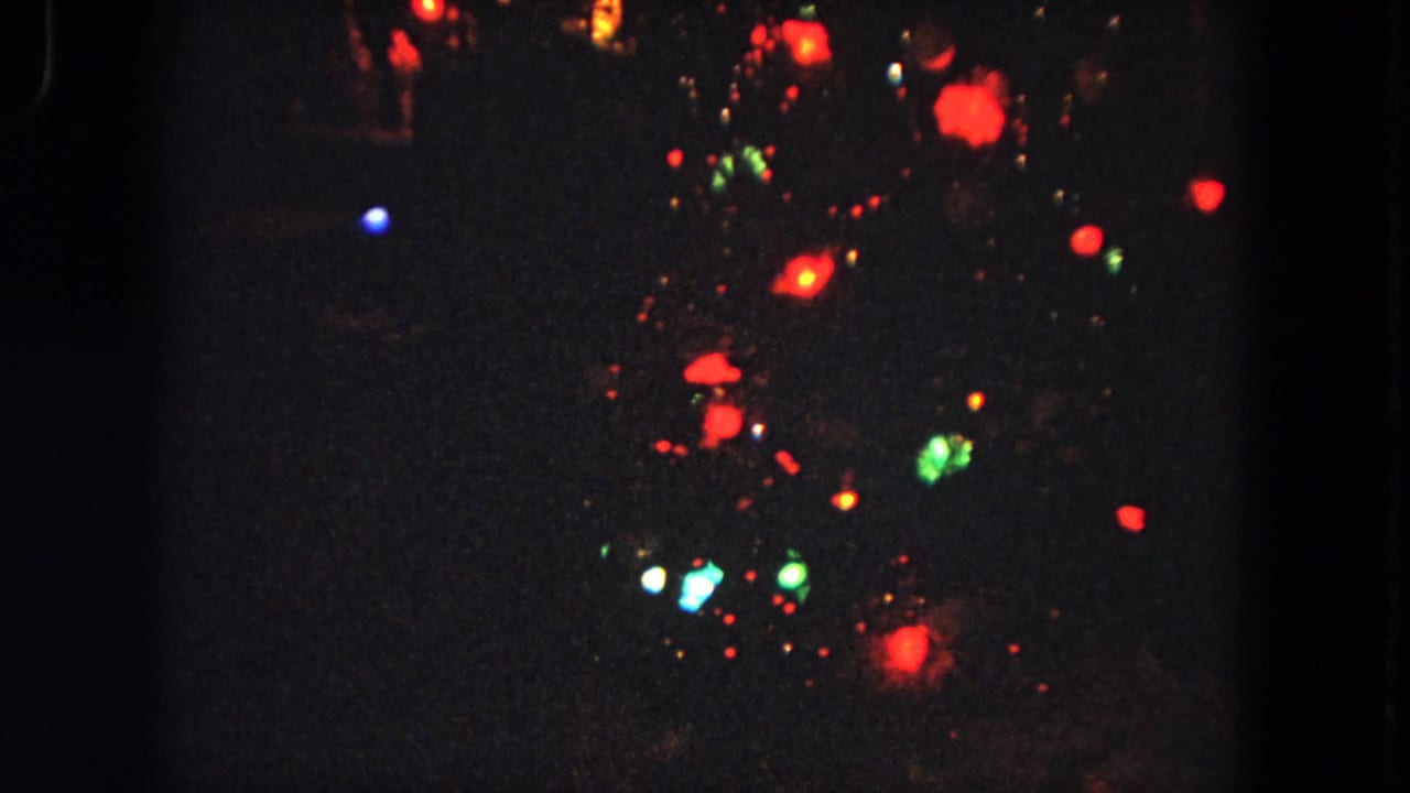 Soft red, green, blue, and white lights scattered against a dark night background.