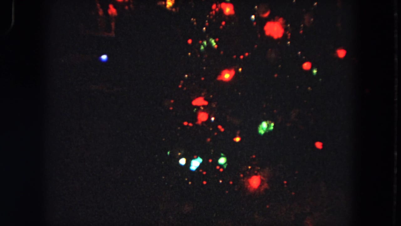Soft-focus 8mm night view from Evanston, Illinois, with colored lights suspended against a nearly black background.