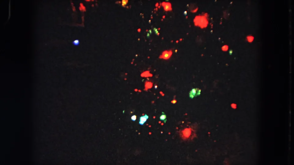 Soft-focus 8mm night view from Evanston, Illinois, with colored lights suspended against a nearly black background.