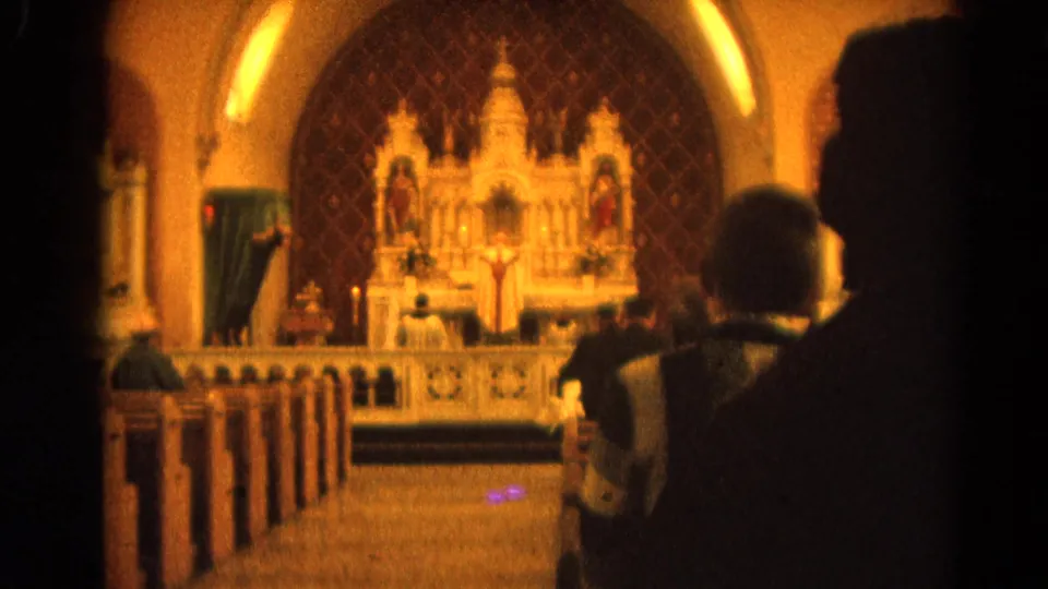 1964 Harvard, Illinois 8mm view from rear pews toward a priest at an ornate Catholic altar.