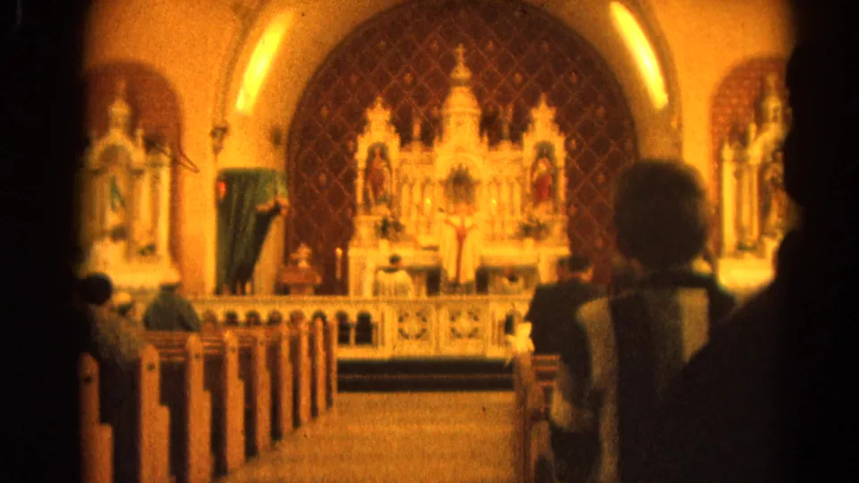 Warm, soft-focus 1964 8mm view of parishioners seated before a Catholic altar in Harvard, Illinois.