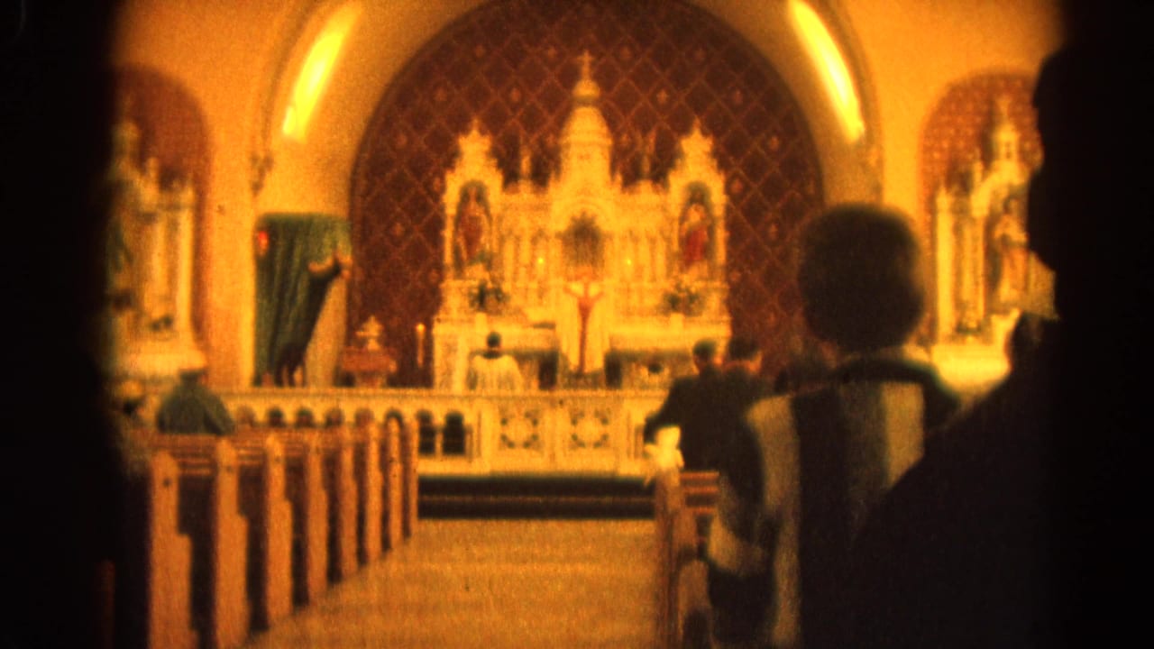 Church interior with parishioners in pews facing clergy at the altar.
