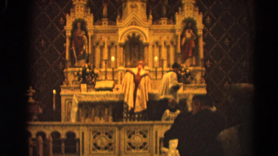 Closer 8mm view of clergy in light vestments at an ornate Catholic altar in Harvard, Illinois, in 1964.