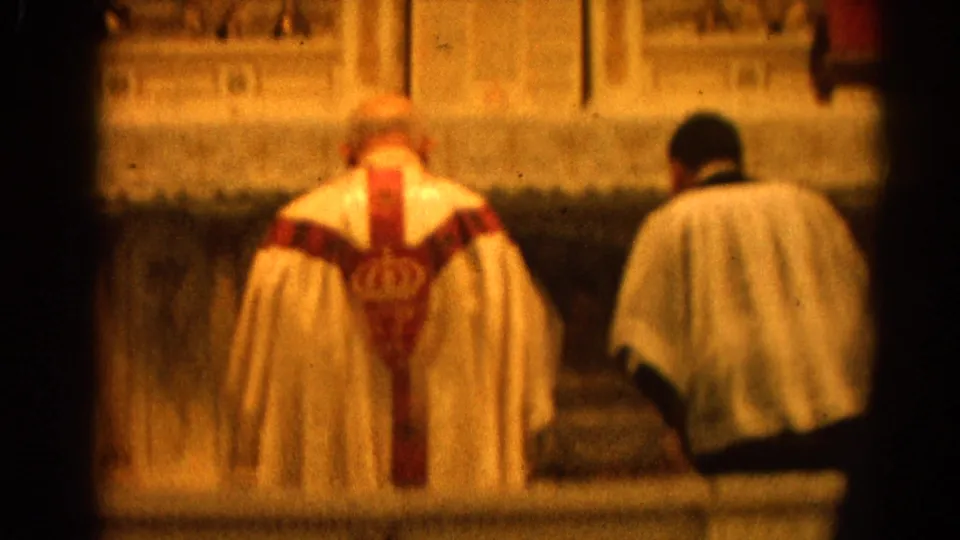 Catholic Mass in Harvard, Illinois, showing priest and assistant facing the altar in a warm, soft 8mm frame.