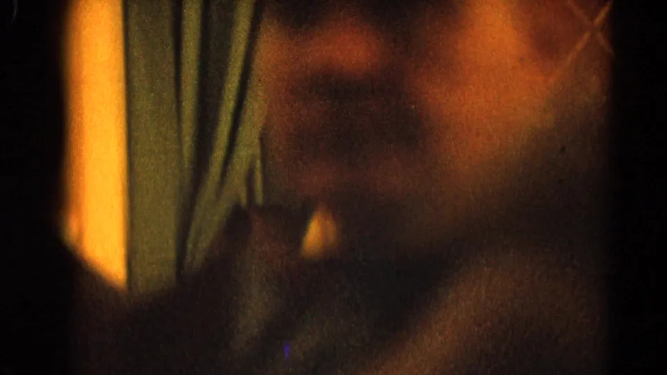Soft, blurred 8mm close-up of a man near blue curtains, likely captured during the same 1964 church gathering.