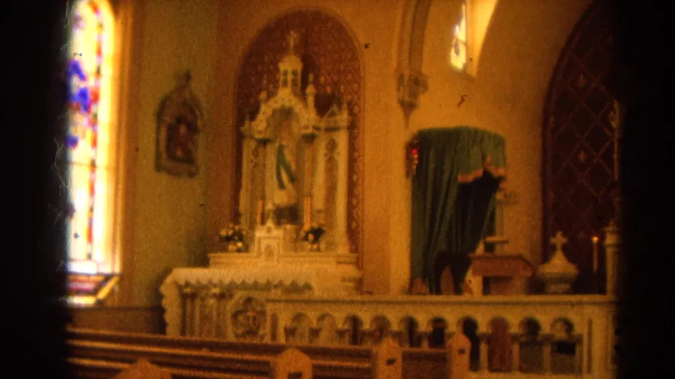 Harvard, Illinois Catholic church altar in warm 8mm color, with stained glass, statuary, candles, and pews visible.