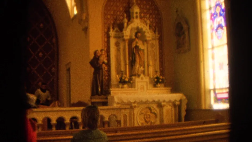 1964 Harvard, Illinois church scene with altar statuary, stained glass, pews, and worshippers seated in a dim sanctuary.