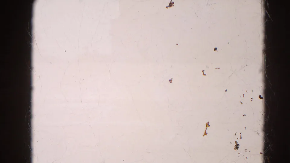 A largely blank 8mm frame area shows pale exposure, dust, scratches, and gate marks from the original film scan.