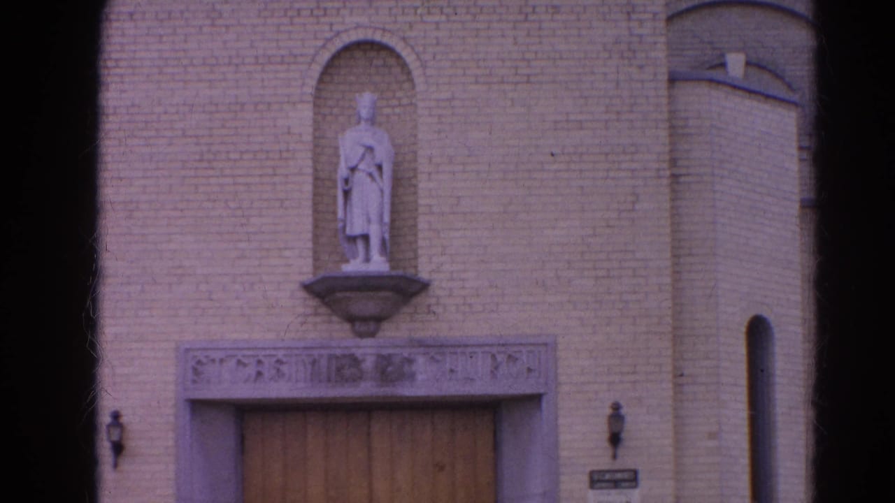 Harvard, Illinois church exterior in 1964, centered on a statue above the entrance with brickwork and a narrow vertical window nearby.