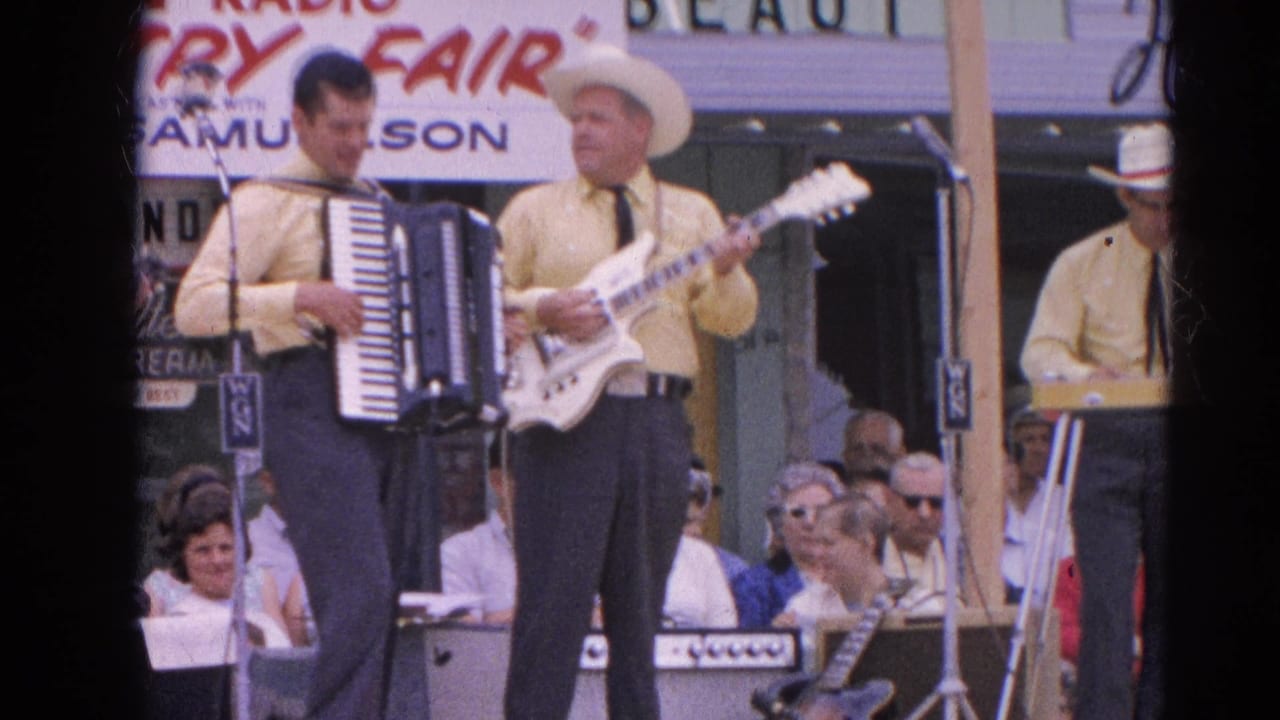 Country band members perform on an outdoor stage before a seated crowd and radio fair sign.