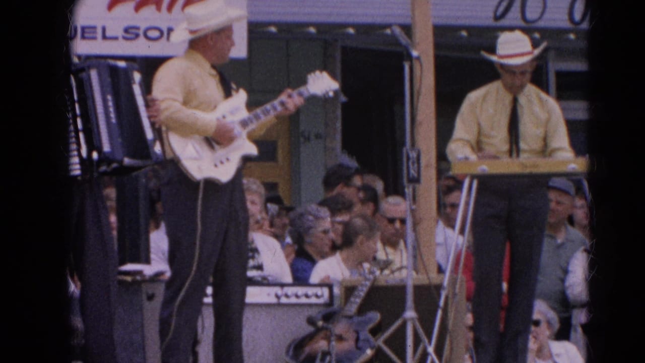A guitarist and keyboard player in matching yellow shirts perform at the Harvard, Illinois fair as spectators watch from close range.
