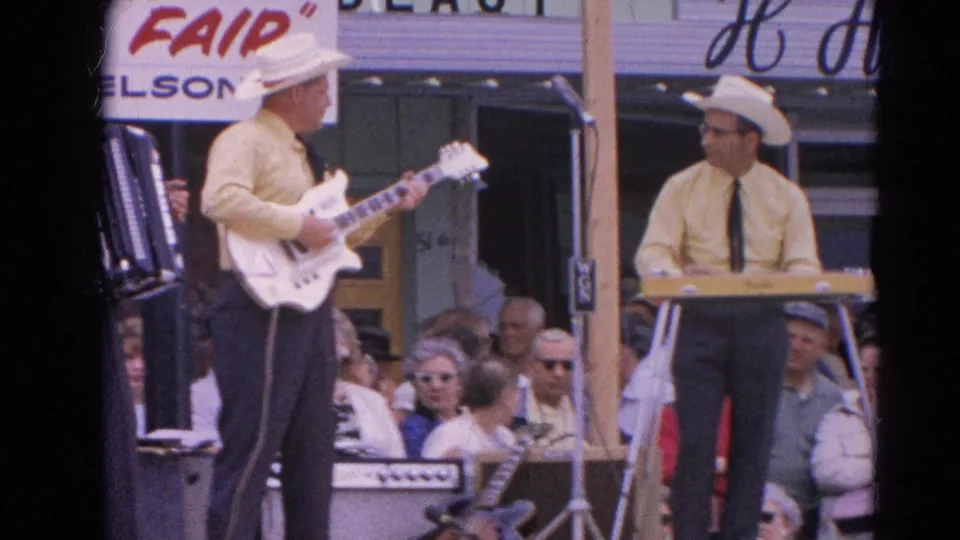 Two fair band members, one with electric guitar and one at keyboard, face each other during the 1964 Harvard, Illinois performance.