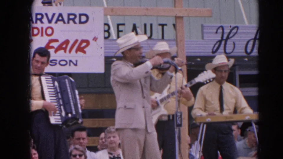 Outdoor 8mm fair footage shows the band mid-performance with visible Harvard Radio Fair signage and crowd faces.