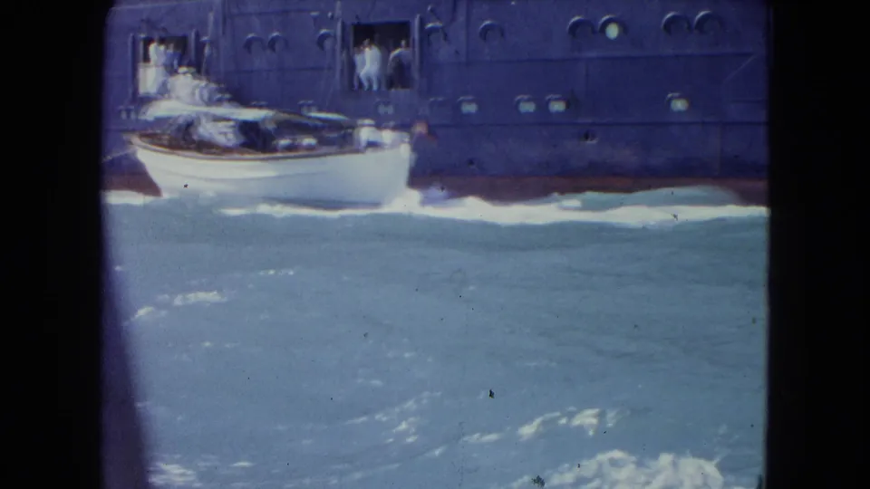 Near the end of the 1964 Kingston shot, the small white boat passes the large liner with people still visible at the side doorway.