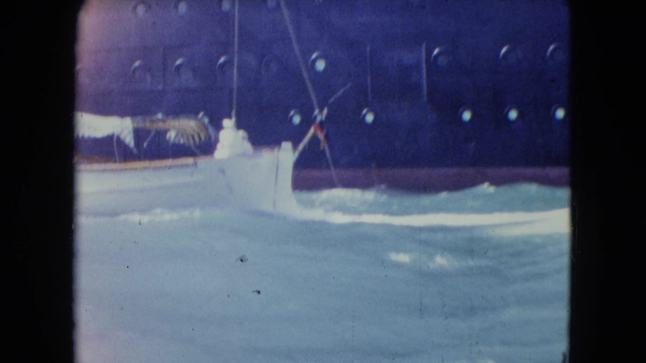 8mm frame showing choppy water against a dark ship hull, likely from the same Kingston travel reel context.