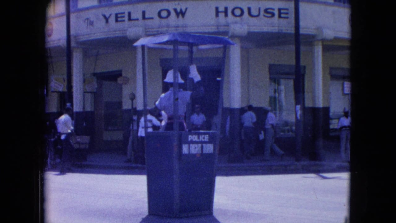 Kingston street view with a white-helmeted officer in a police booth marked no right turn before The Yellow House.