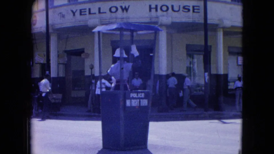 Kingston street view with a white-helmeted officer in a police booth marked no right turn before The Yellow House.