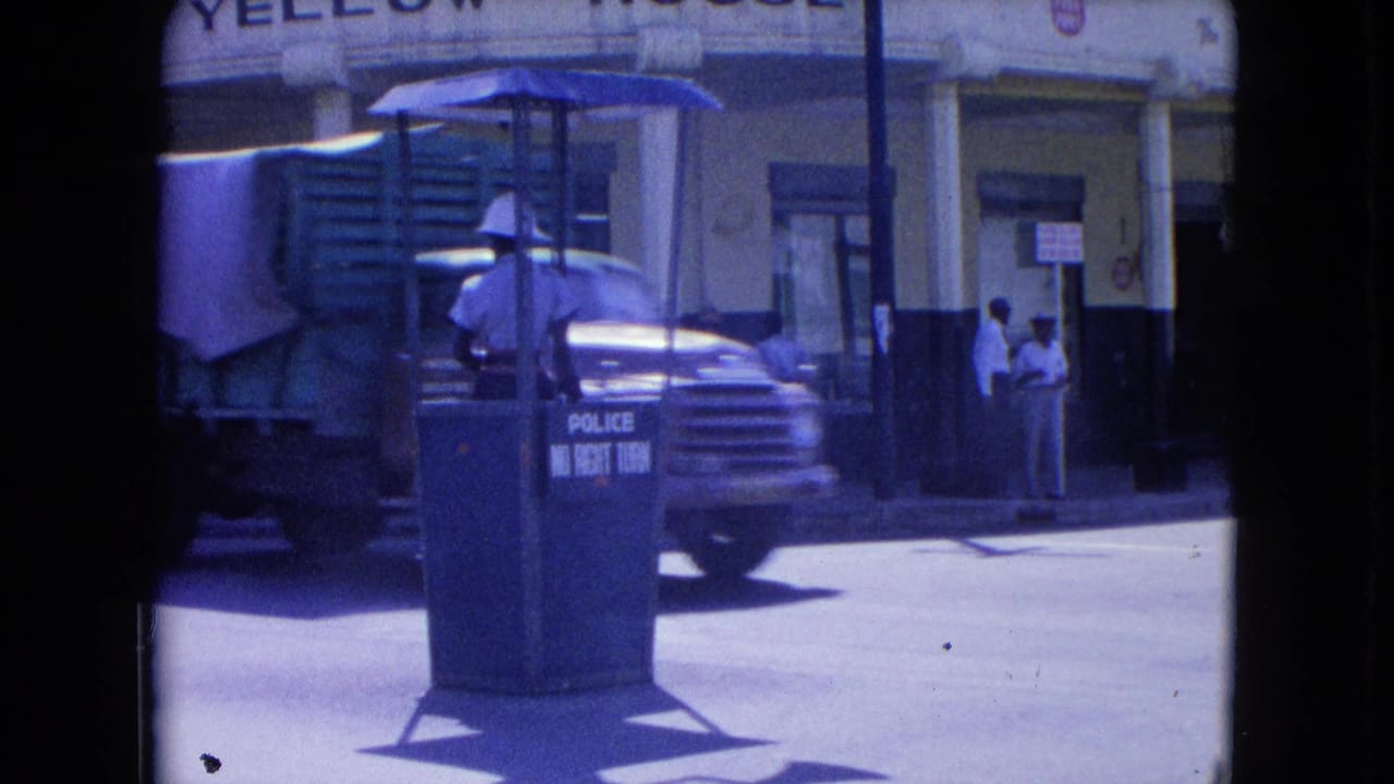 Truck passes a police traffic booth in front of the Yellow House building.