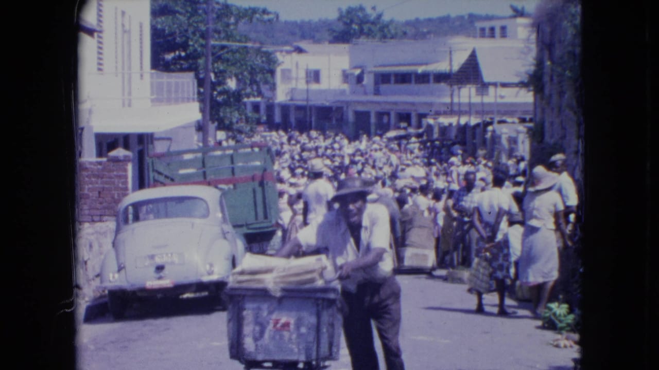 Crowded street scene with a loaded bicycle in the foreground and vehicles along the curb.