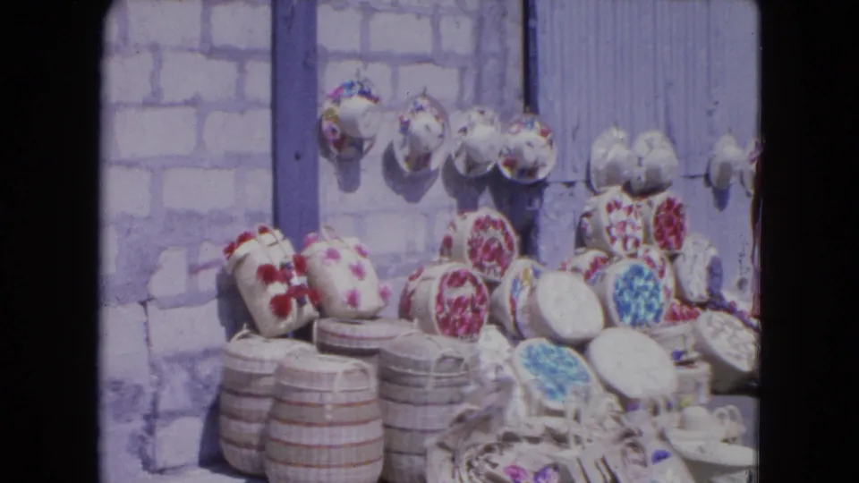 Handwoven hats and baskets with floral designs fill the frame in a Kingston, Jamaica market display from 1964.