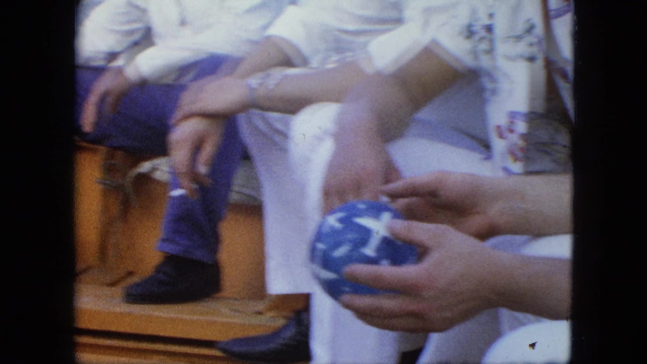 Close view of seated adults on a boat, one holding a blue patterned ball.