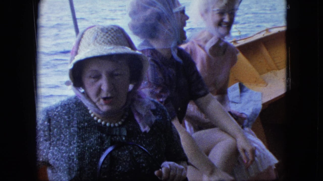 Woman in straw hat and pearls sits in front while two other women smile behind her on a boat.