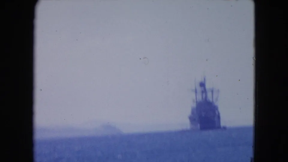 Distant naval vessel at sea near Montego Bay, Jamaica, seen through soft blue 1964 8mm footage.