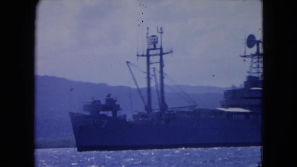 Closer 1964 8mm view of a naval ship's bow, mast, and upper deck near Montego Bay, Jamaica.