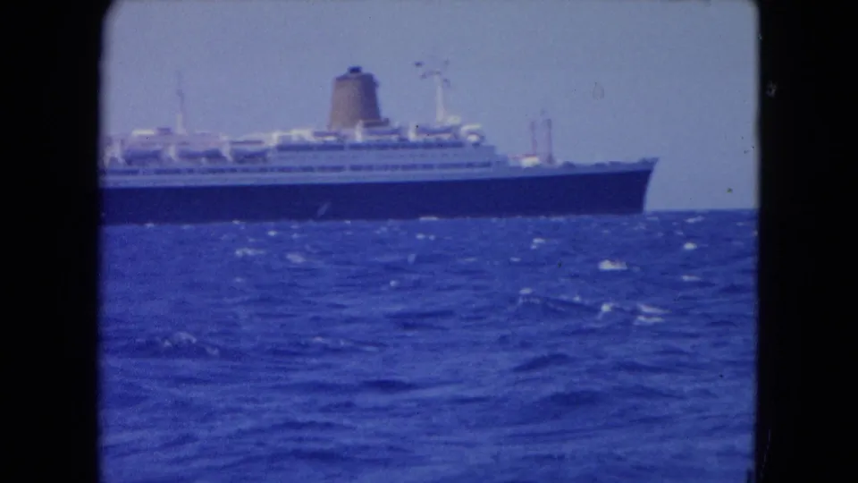 1964 Montego Bay footage shows a large ocean liner on the horizon beyond choppy blue water.