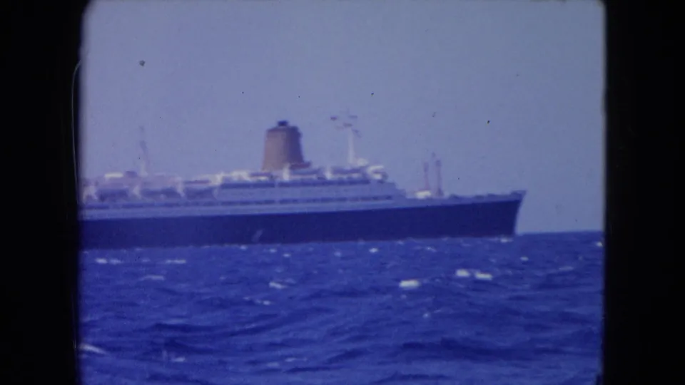 Distant ocean liner at sea near Montego Bay, filmed in soft 8mm color from a moving boat.