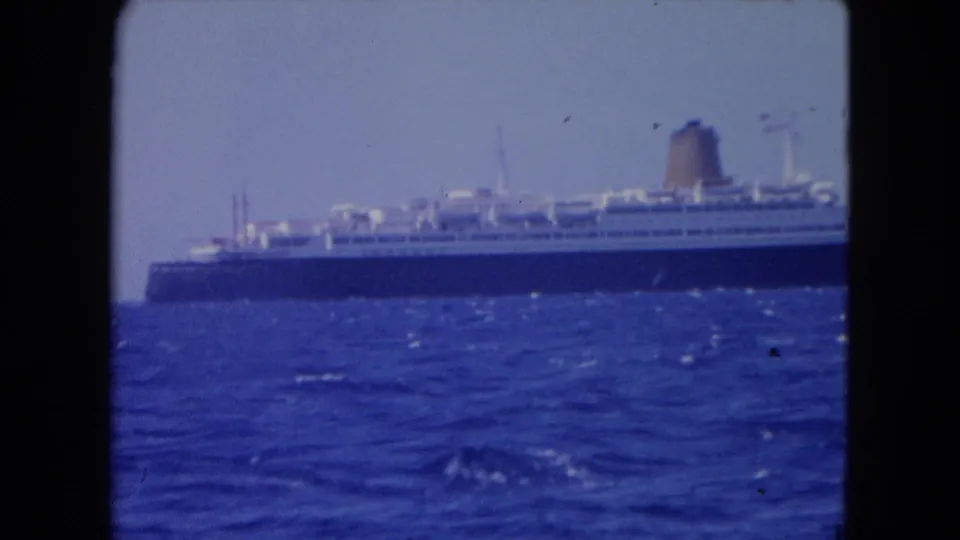 Large passenger ship with white decks and dark hull moving across open water near Montego Bay in 1964 footage.