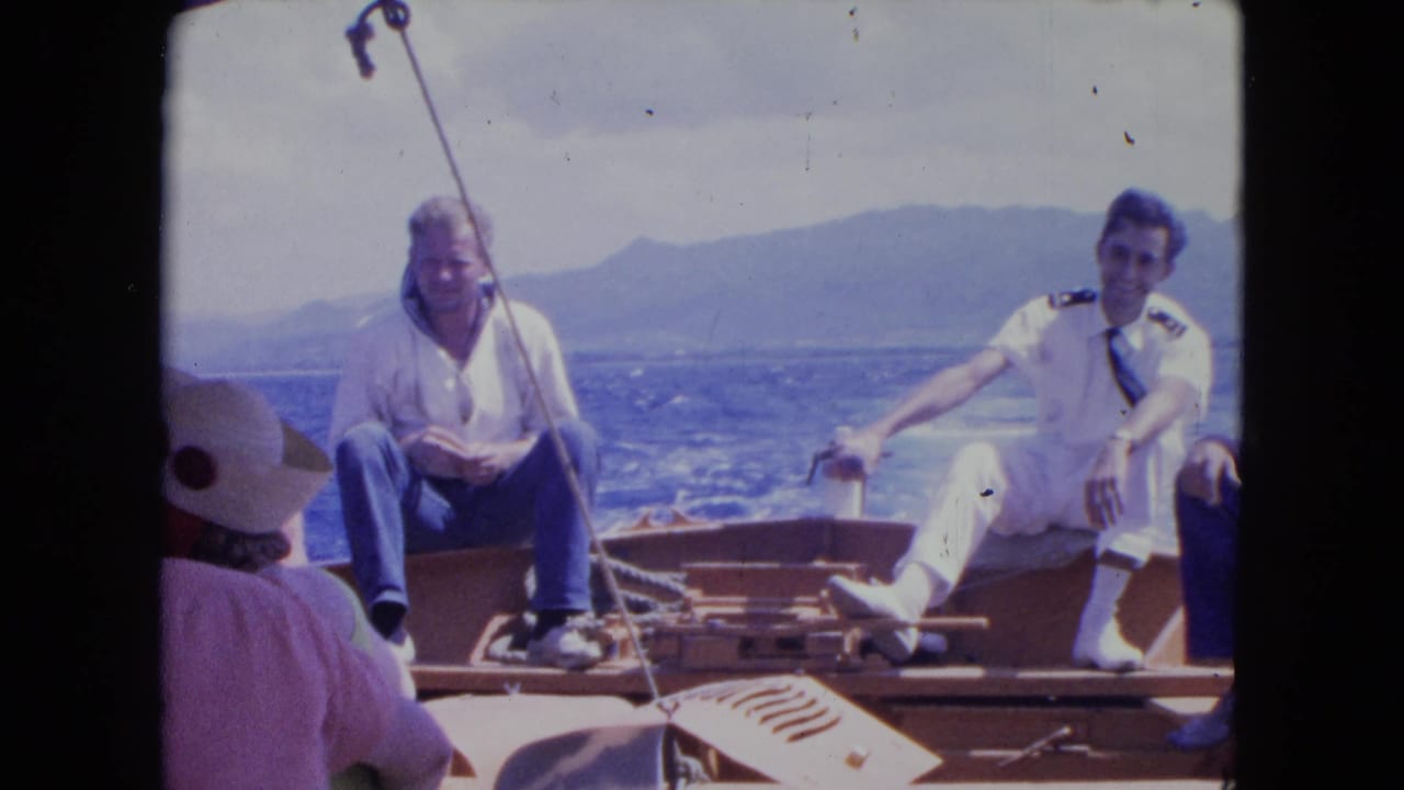 Two men sit on a wooden boat while another passenger is partly visible in front.