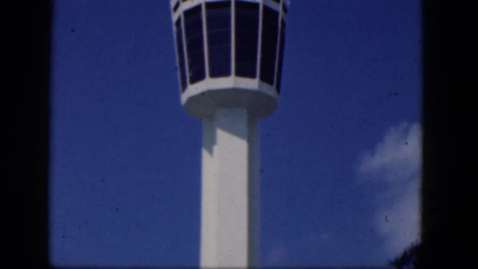 A white airport control tower cab and shaft appear near the top of the frame in this 1964 Niagara Falls, Canada home-movie still.