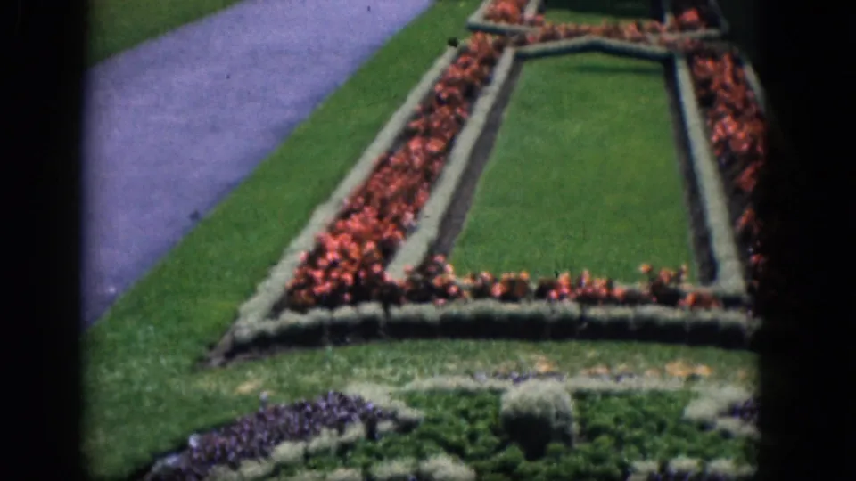 1964 Niagara Falls, Canada frame showing the garden bed filling the foreground, with a path and partial waterfall view beyond.