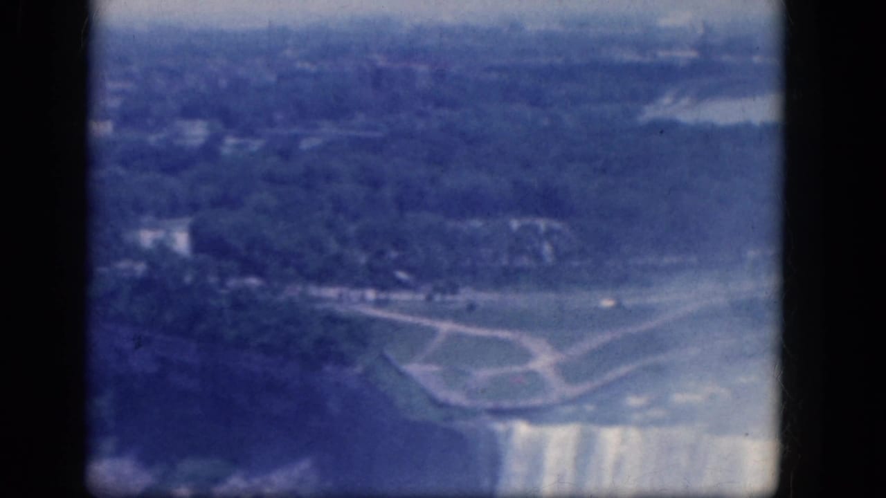 Aerial view of Horseshoe Falls brink with mist, shoreline, and park paths.