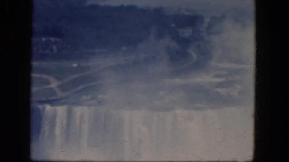 End of the 1964 Niagara Falls pan, with mist covering part of Horseshoe Falls and parkland visible above the cascade.