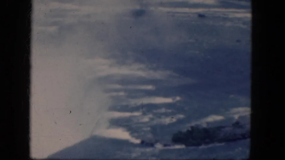 1964 Niagara Falls, Canada home-movie frame showing blue water, shoreline rocks, and visible 8mm gate borders.