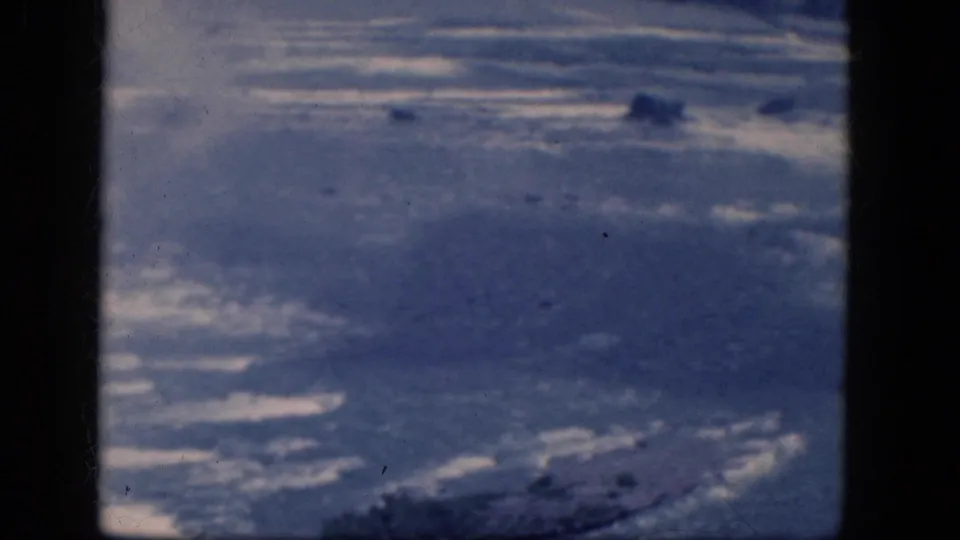 1964 Niagara Falls, Canada home-movie frame showing rippled blue water, rocks, and strong film-gate borders.
